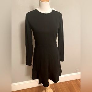 Classic black dress with white ruffles around the neckline